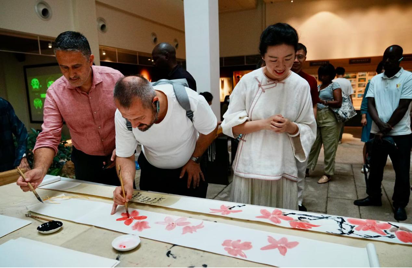Branko Zujovic paints red silk-cotton with other journalists at the 2023 Belt and Road Media Workshop in Guangzhou, Guangdong Province, October 25, 2023. (Photos: People's Daily/Yang Shuobi and Wang Yan)