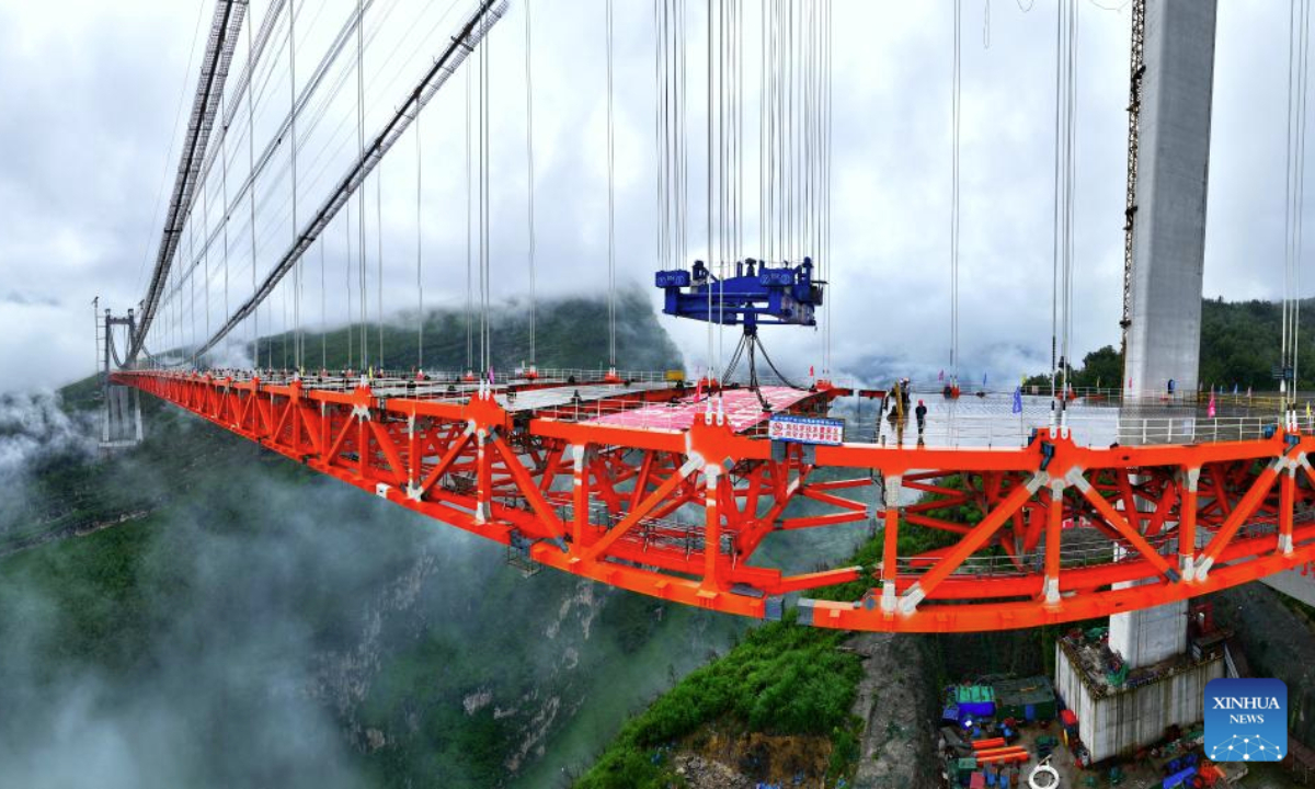 An aerial drone photo taken on Sept. 23, 2025 shows the Tianmen grand bridge under construction in southwest China's Guizhou Province. The Tianmen grand bridge on the Anshun-Panzhou highway, with a length of 1,553 meters and the bridge floor hung about 560 meters above the canyon water, finished its closure on Tuesday. (Xinhua/Liu Xu)