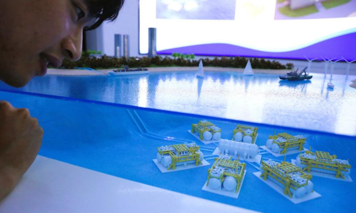 A visitor observes a miniature model of undersea data cabins for an undersea data center, in Lingshui, south China's Hainan Province, Sept. 25, 2025. (Xinhua/Zheng Yue)