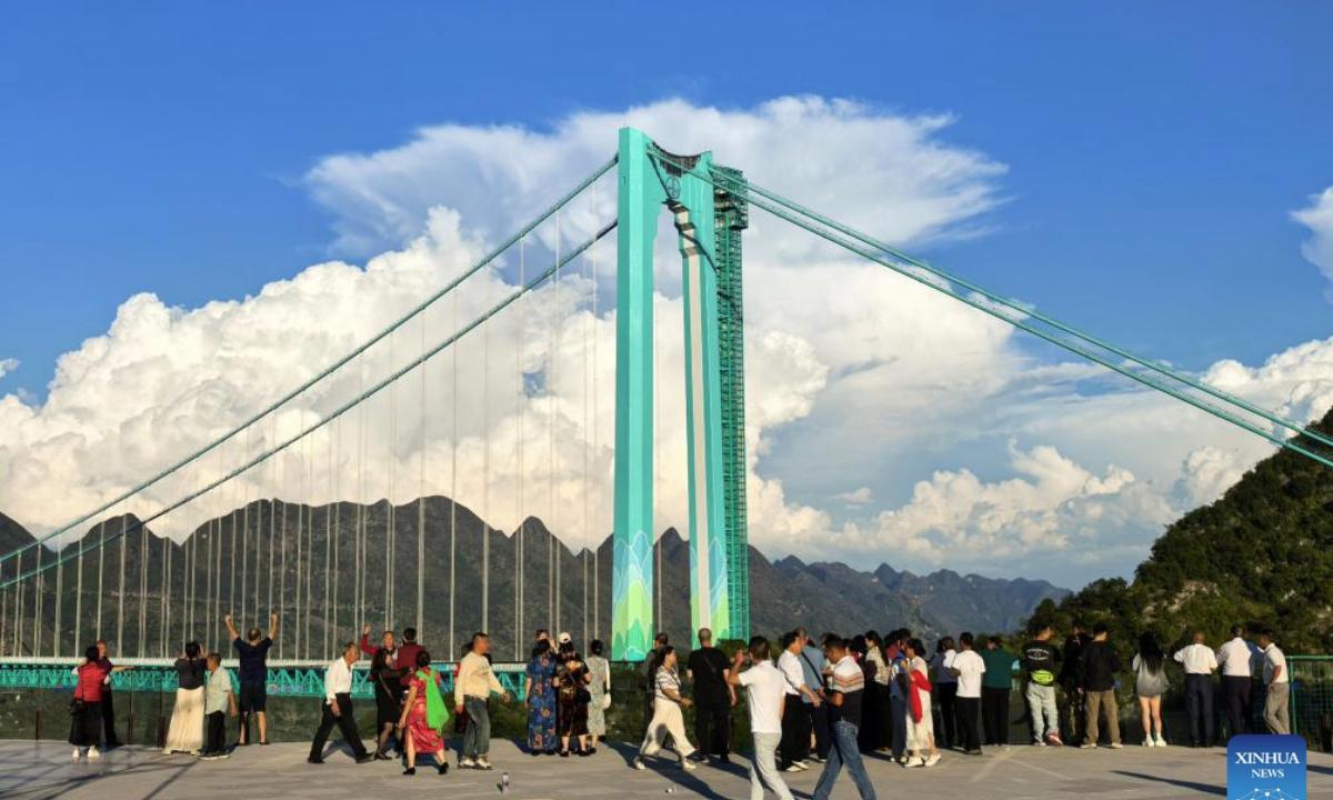 This photo taken with a mobile phone on Sept. 28, 2025 shows tourists viewing the Huajiang Grand Canyon Bridge in southwest China's Guizhou Province. (Xinhua/Yang Wenbin)