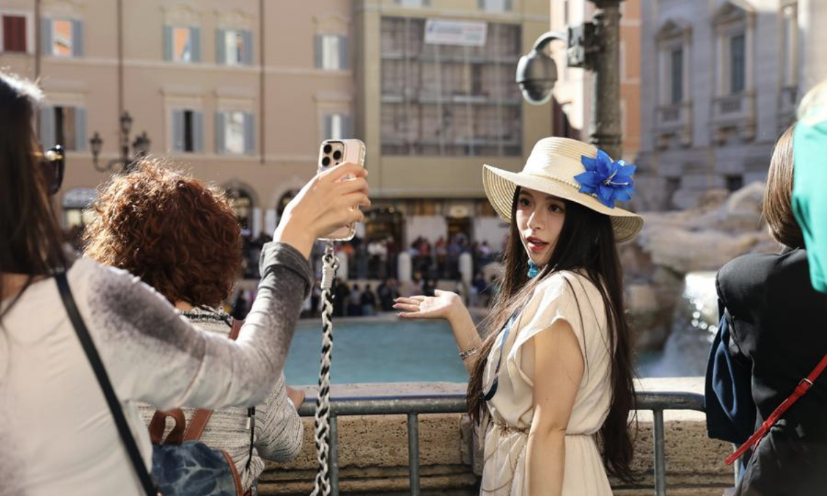 A Chinese tourist poses for photos in front of the Trevi Fountain in Rome, Italy, Oct. 6, 2025. (Xinhua/Li Jing)