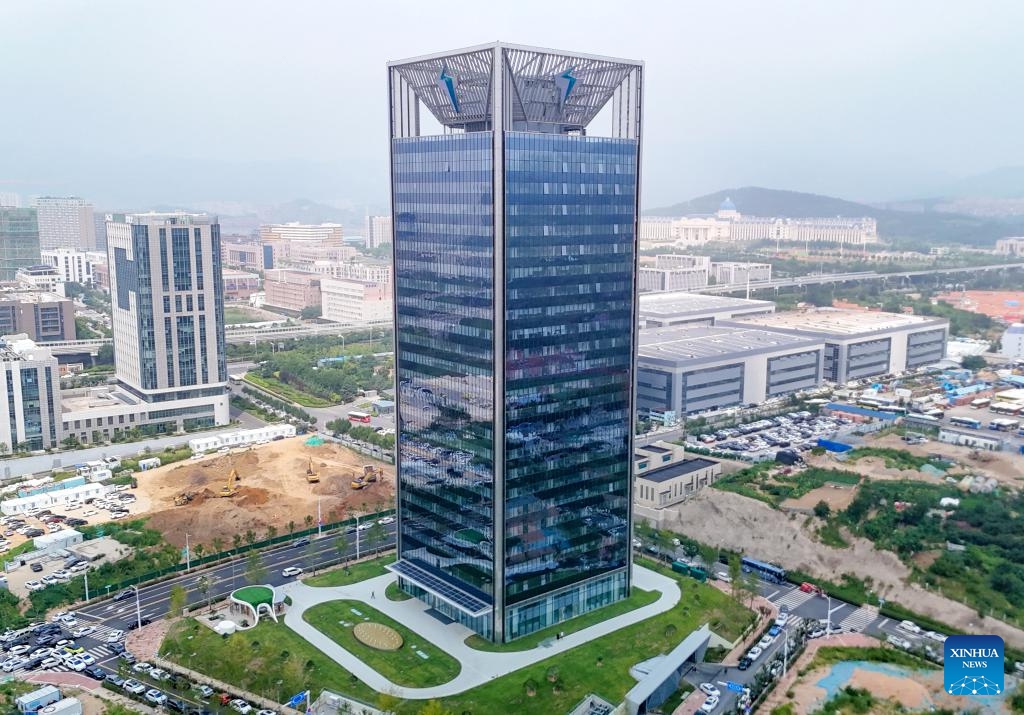 An aerial drone photo taken on Aug. 25, 2025 shows the world's first ultra zero-carbon building, the headquarters of EV charging pile network operator TELD New Energy, in Qingdao, east China's Shandong Province. Equipped with cutting-edge high-tech solutions to achieve 100 percent green energy substitution, the building was put into operation Sunday in Qingdao. (Photo by Zhang Jingang/Xinhua)