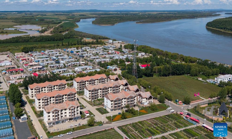 An aerial drone photo taken on Aug. 21, 2025 shows the residential area beside the Wusuli River in Sipai Hezhe Ethnic Township, Raohe County, northeast China's Heilongjiang Province. Sipai Hezhe Ethnic Township is one of the main settlements of the Hezhe ethnic group in China, and also the birthplace of Wusuli River, a Hezhe folk song popular across the country. (Xinhua/Xie Jianfei)