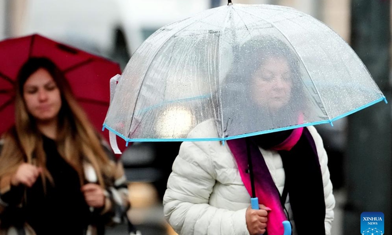 People walk against rainfall in Riga, Latvia, Aug. 26, 2025. Riga was struck by severe thunderstorms overnight into the morning of Aug. 26, with heavy rain causing flooding in some streets of the city center. (Photo by Edijs Palens/Xinhua)