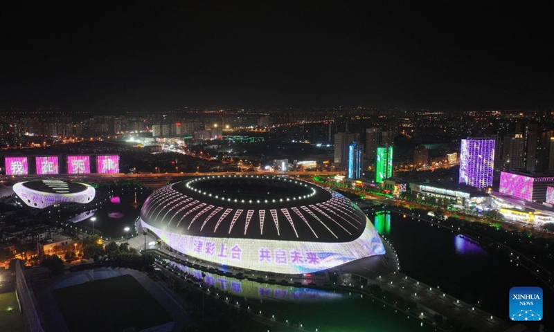 An aerial drone photo taken on Aug. 22, 2025 shows a night view of the Tianjin Olympic Center Stadium in north China's Tianjin. The SCO Summit 2025 will be held here from Aug. 31 to Sept. 1. (Xinhua/Li Ran)
