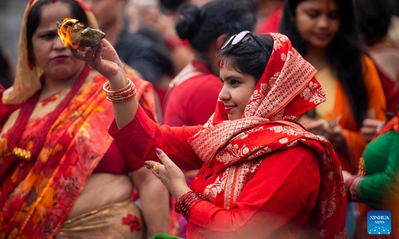 A woman performs a ritual prayer celebrating the Teej Festival at the Pashupatinath Temple in Kathmandu, Nepal, Aug. 26, 2025. During the festival, married women fast and pray for good health and longevity of their husbands and unmarried women pray for marrying ideal husbands. (Photo by Hari Maharjan/Xinhua)