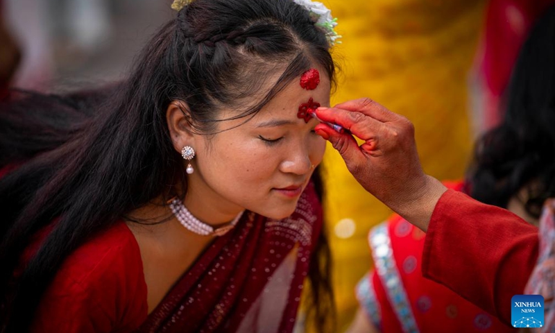 A woman receives tika during a celebration of the Teej Festival at the Pashupatinath Temple in Kathmandu, Nepal, Aug. 26, 2025. During the festival, married women fast and pray for good health and longevity of their husbands and unmarried women pray for marrying ideal husbands. (Photo by Hari Maharjan/Xinhua)