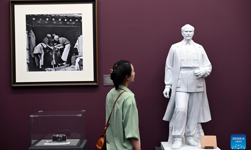 A visitor views a sculpture of the Canadian surgeon Norman Bethune, who led his medical team to China in 1938 to help Chinese people fight against Japanese invaders and sacrificed his life in November 1939, at an art exhibition highlighting the Chinese People's War of Resistance Against Japanese Aggression in Beijing, capital of China, Aug. 26, 2025. (Xinhua/Jin Liangkuai)