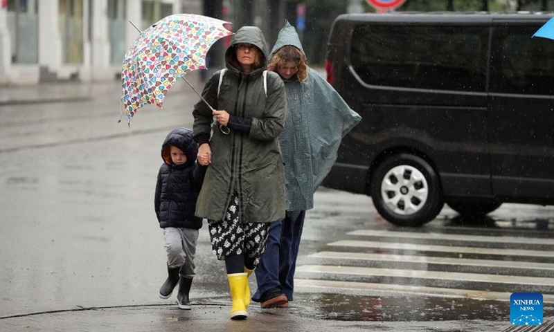 People walk against rainfall in Riga, Latvia, Aug. 26, 2025. Riga was struck by severe thunderstorms overnight into the morning of Aug. 26, with heavy rain causing flooding in some streets of the city center. (Photo by Edijs Palens/Xinhua)