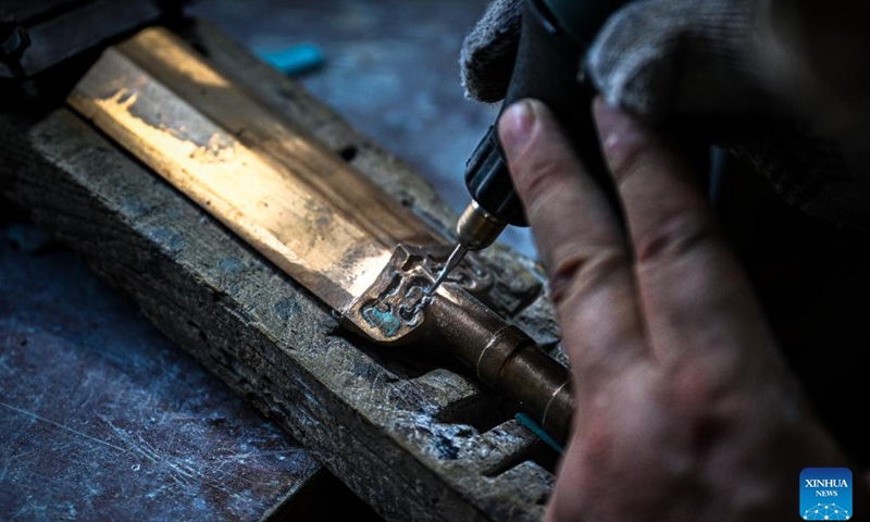 Ao Xinghua inlays turquoise into the handguard of a sword at Ao's family workshop in Buhe Town of Jingzhou City, central China's Hubei Province, June 16, 2025.