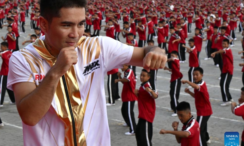 China's boxer Yeerjialahasi Laayibieke leads students of Shaolin Tagou Martial Arts School to practise boxing during the celebration of the International Boxing Day held by the International Boxing Association (IBA) in Dengfeng, Zhengzhou, central China's Henan Province, Aug, 27, 2025. (Xinhua/Li Jianan)