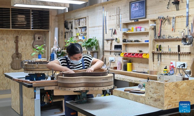 A worker makes a guitar at a workshop in Songzi City, central China's Hubei Province, Aug. 28, 2025. The guitar making industry has become the city's signature industry. (Xinhua/Du Zixuan)