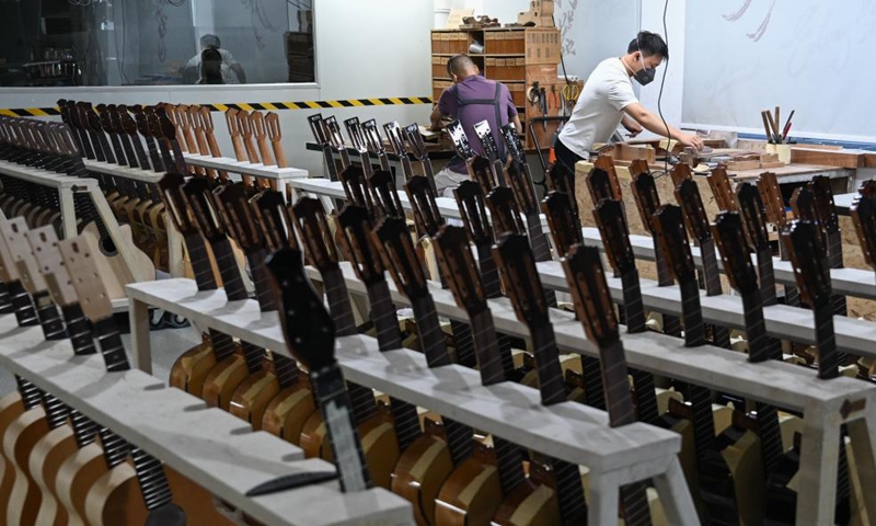 Workers make guitars at a workshop in Songzi City, central China's Hubei Province, Aug. 28, 2025. The guitar making industry has become the city's signature industry. (Xinhua/Du Zixuan)