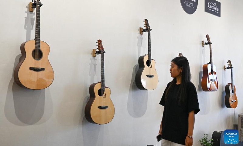 A visitor views the guitar products at a guitar company in Songzi, central China's Hubei Province, Aug. 28, 2025. The guitar making industry has become the city's signature industry. (Xinhua/Du Zixuan)