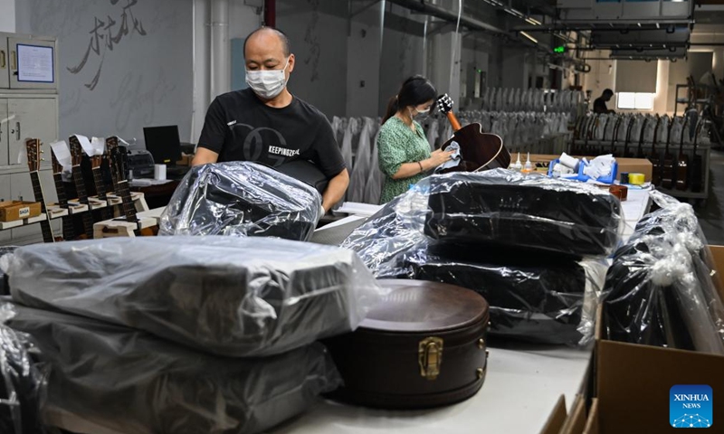 Workers pack guitars at a workshop in Songzi City, central China's Hubei Province, Aug. 28, 2025. The guitar making industry has become the city's signature industry. (Xinhua/Du Zixuan)