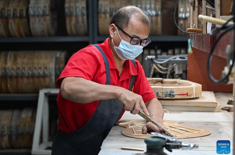 A worker makes a guitar at a workshop in Songzi City, central China's Hubei Province, Aug. 28, 2025. The guitar making industry has become the city's signature industry. (Xinhua/Du Zixuan)