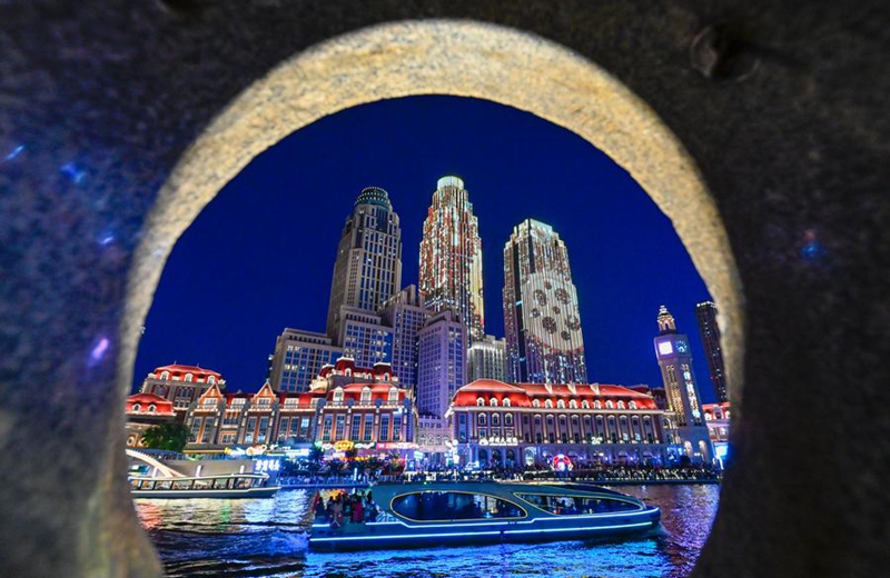 People take boats to enjoy the night view on the Haihe River in north China's Tianjin, Aug. 25, 2025. (Photo by Du Penghui/Xinhua)