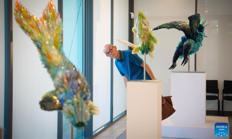 A visitor observes the sculptures displayed at the Glass Menagerie exhibition by Polish-born artist Marta Klonowska at the Ursynow Cultural Center in Warsaw, Poland, on Aug. 29, 2025. The exhibition presents a collection of animal sculptures created from thousands of pieces of colored glass wastes. (Photo: Xinhua)