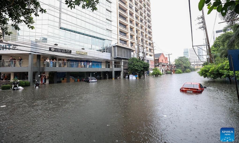 A car is seen partially submerged in floodwater at a street during a heavy rain in Quezon City, the Philippines, on Aug. 30, 2025. (Photo: Xinhua)