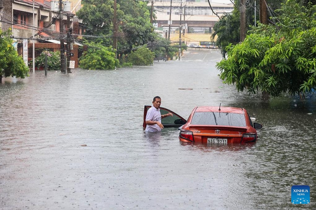 A car is seen partially submerged in floodwater at a street during a heavy rain in Quezon City, the Philippines, on Aug. 30, 2025.(Photo: Xinhua)
