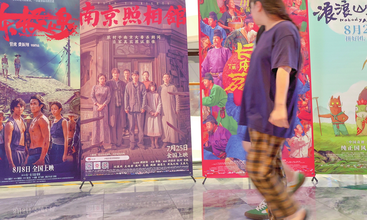 A person walks past movie posters at a cinema in Beijing on August 31, 2025. China's 2025 summer box office reached just over 11.96 billion yuan ($1.68 billion), surpassing last year's summer total, the China Film Administration announced on September 1, 2025. Photo: VCG