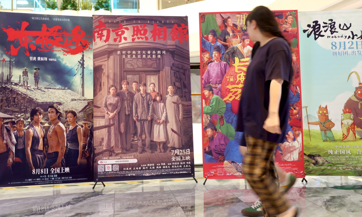 Citizens walk past movie posters at a cinema in Beijing on August 31. Photo:VCG
