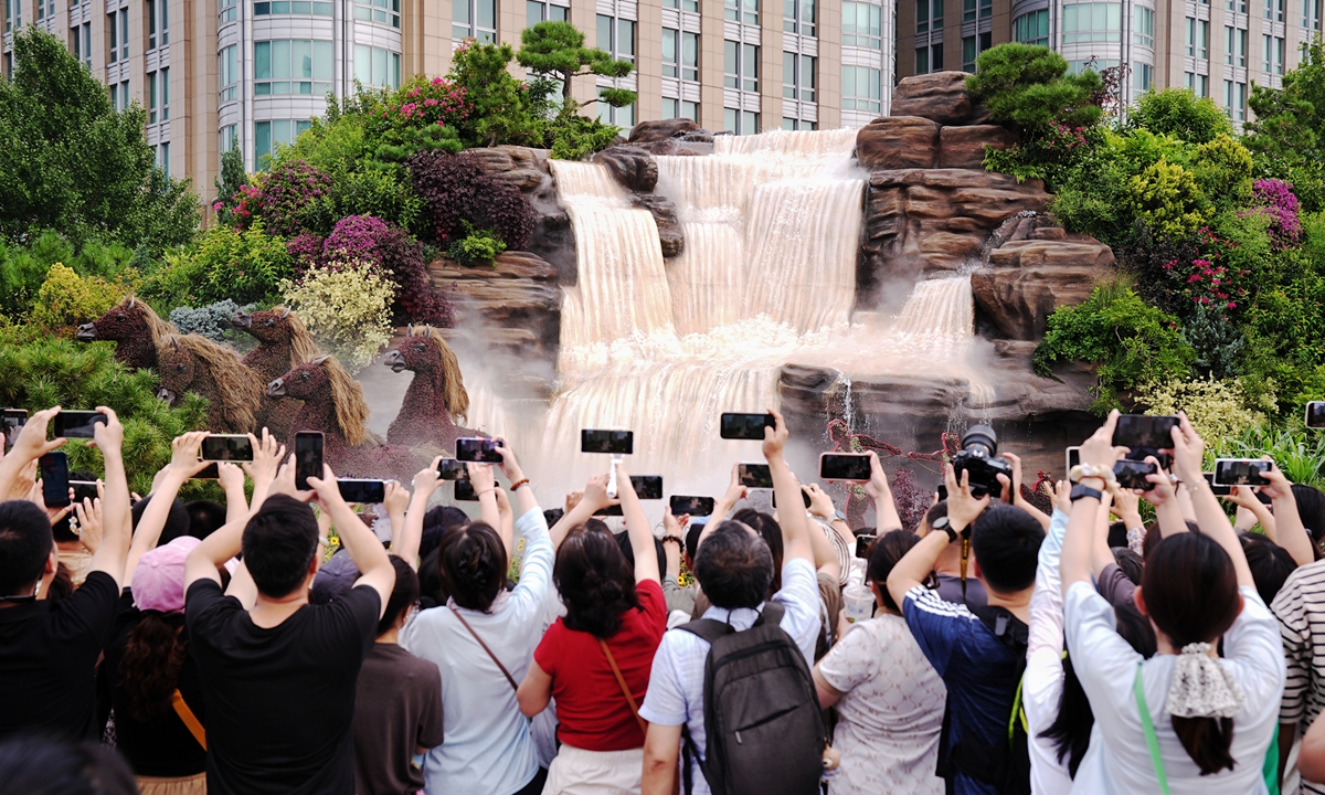 Residents and tourists take photos at a themed flowerbed commemorating the 80th anniversary of the victory in the Chinese People's War of Resistance against Japanese Aggression and the World Anti-Fascist War in Beijing on September 2, 2025. Photo: VCG