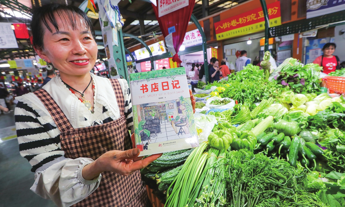 A vendor recommends a book to customers in a food market. Photos: VCG