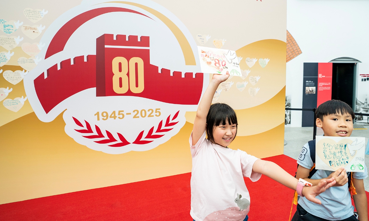 Two children display their written messages in an event to commemorate the 80th anniversary of the victory in the Chinese People's War of Resistance Against Japanese Aggression and the World Anti-Fascist War in Hong Kong on September 3, 2025. Photo: VCG