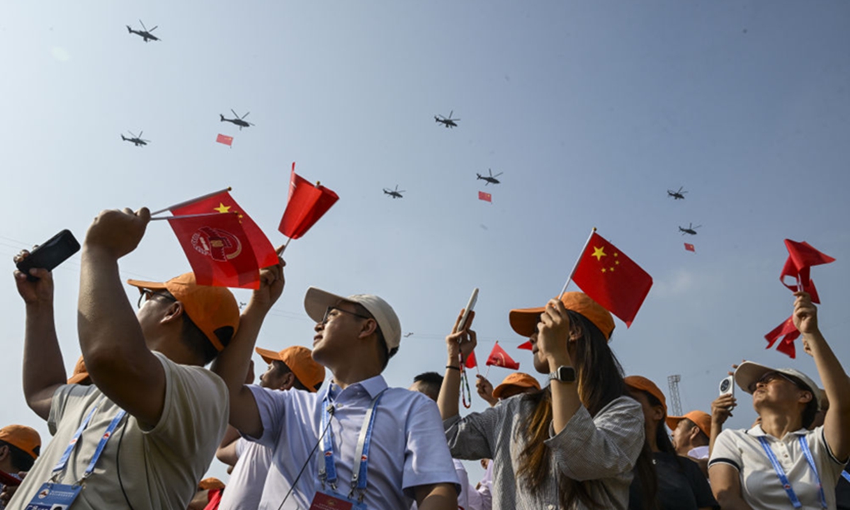 Audience wave the five-star red flags as they watch the military parade held in Beijing on September 3, 2025 to mark the 80th anniversary of the victory in the Chinese People's War of Resistance against Japanese Aggression and the World Anti-Fascist War. Photo: Xinhua