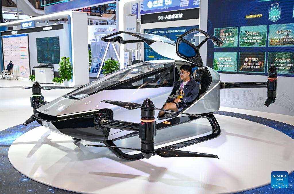 A journalist sits in an electric vertical take-off-and-landing (eVTOL) aircraft at the venue of the World Smart Industry Expo 2025 in southwest China's Chongqing, Sept. 4, 2025. The expo is scheduled for Sept. 5 to 8 in Chongqing to present cutting-edge achievements of the smart industry through professional exhibitions. (Photo: Xinhua)