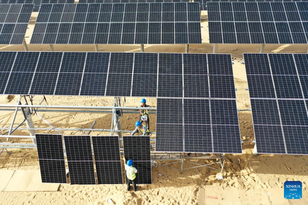 An aerial drone photo taken on Sept. 2, 2025 shows workers installing photovoltaic panels at a new energy base in Kubuqi Desert, north China's Inner Mongolia Autonomous Region. In recent years, Inner Mongolia has carried out integrated projects for sand prevention and control as well as wind and photovoltaic power to advance the improvement efforts in Kubuqi Desert. To date, photovoltaic bases have been established in the northern part of Kubuqi Desert, which also serve as solid booster for local ecological rehabilitation and economic growth. (Photo: Xinhua)