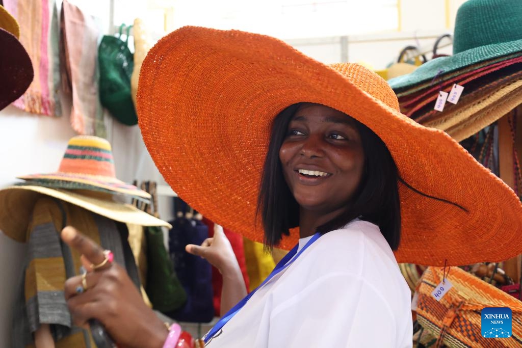A woman tries on a hat at the fourth Made-in-Ghana Bazaar in Accra, Ghana, Sept. 5, 2025. The three-day event opened here on Friday. (Photo: Xinhua)
