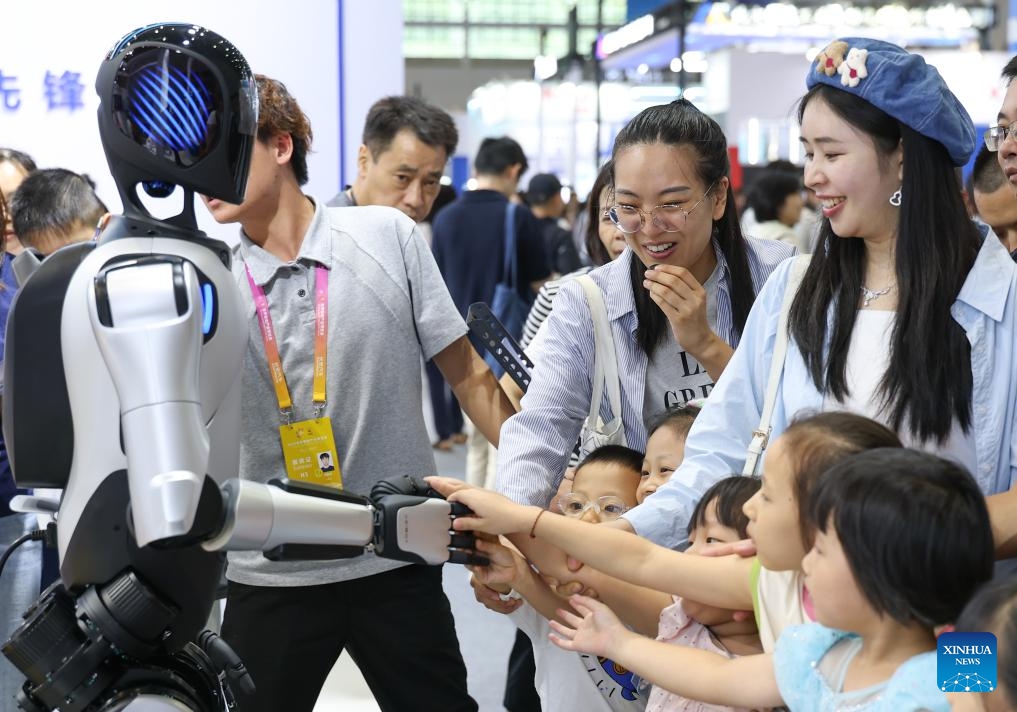 Visitors interact with a home service robot during the World Smart Industry Expo 2025 in southwest China's Chongqing Municipality, Sept. 6, 2025. The World Smart Industry Expo 2025 kicked off on Friday in southwest China's Chongqing Municipality, showcasing advanced achievements including AI rehabilitation systems, portable wearable devices, elderly care robots, and senior-friendly equipment. (Photo: Xinhua)