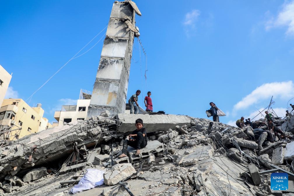 Palestinians are seen near a destroyed tower following an Israeli airstrike in Gaza City on Sept. 6, 2025. The Israeli army destroyed a 15-floor residential tower in Gaza City on Saturday, a day after it flattened another high-rise, as part of its expanding military operations across the enclave. (Photo: Xinhua)