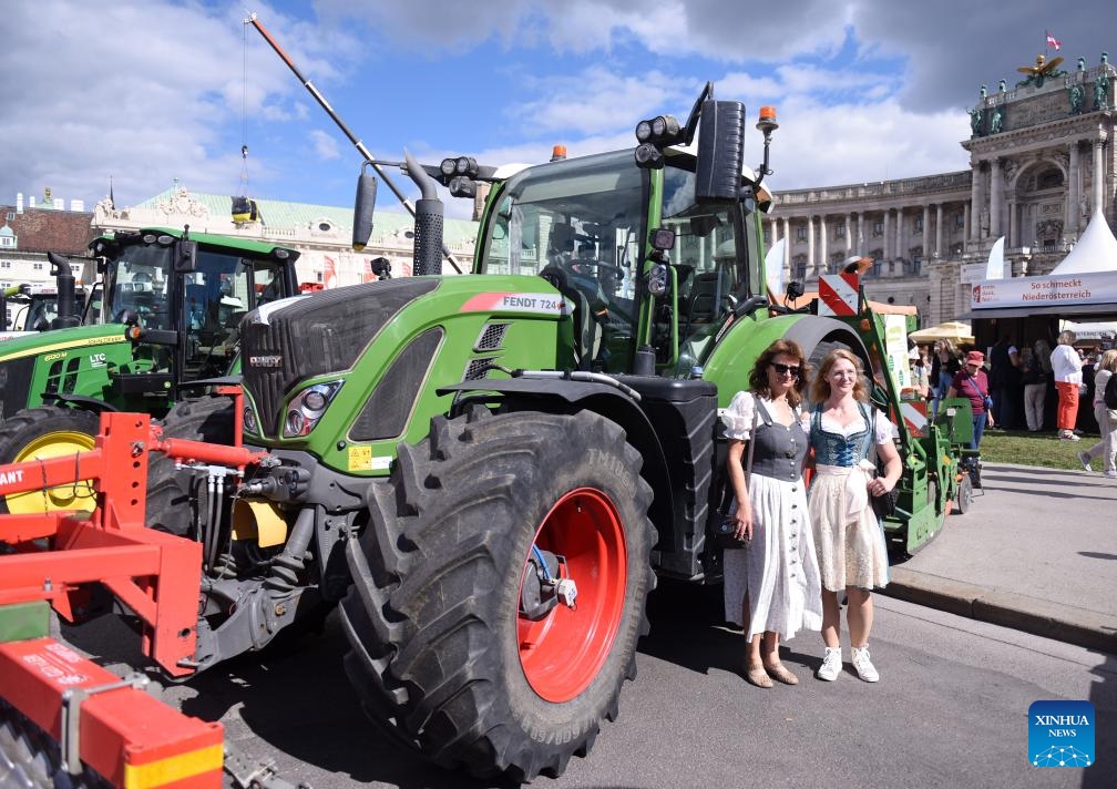People pose for a photo with agricultural machinery during a harvest festival (the Erntedankfest) in Vienna, Austria, Sept. 6, 2025. The festival was held in Vienna on Sept. 6 to 7. (Photo: Xinhua)