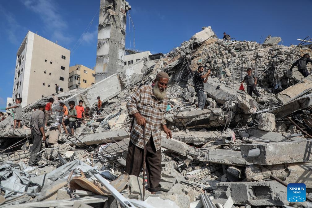 Palestinians are seen near a destroyed tower following an Israeli airstrike in Gaza City on Sept. 6, 2025. The Israeli army destroyed a 15-floor residential tower in Gaza City on Saturday, a day after it flattened another high-rise, as part of its expanding military operations across the enclave. (Photo: Xinhua)