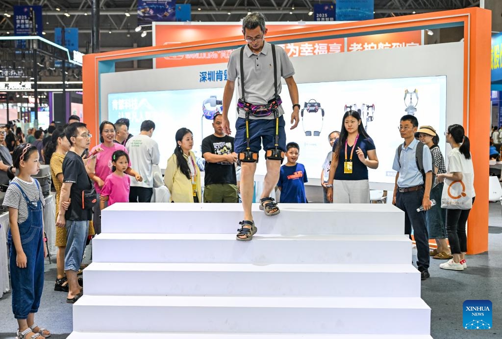A visitor tries an exoskeleton robot during the World Smart Industry Expo 2025 in southwest China's Chongqing Municipality, Sept. 7, 2025. The World Smart Industry Expo 2025 kicked off on Friday in southwest China's Chongqing Municipality, showcasing advanced achievements including AI rehabilitation systems, portable wearable devices, elderly care robots, and senior-friendly equipment. (Photo: Xinhua)