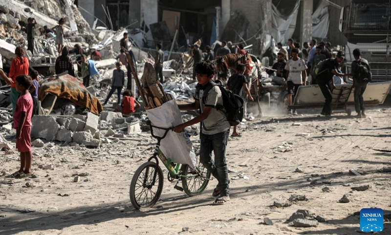 Palestinians are seen near a destroyed tower following an Israeli airstrike in Gaza City on Sept. 6, 2025. The Israeli army destroyed a 15-floor residential tower in Gaza City on Saturday, a day after it flattened another high-rise, as part of its expanding military operations across the enclave. (Photo: Xinhua)