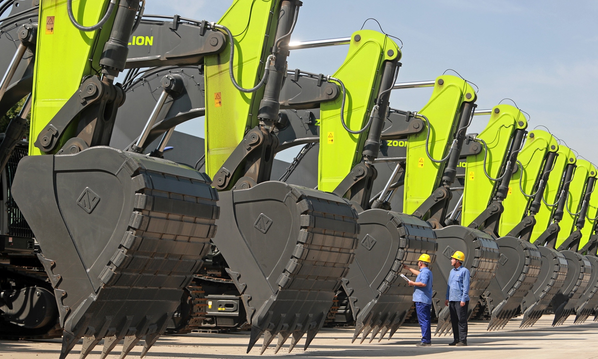 Workers inspect a row of giant excavators inside a factory in Weinan, Northwest China's Shaanxi Province, on September 9, 2025, before they are sent to customers. From January to August, 154,181 Chinese-made excavators were sold in the domestic and foreign markets, a year-on-year increase of 17.2 percent, the Securities Times reported, citing industry data. Photo: VCG