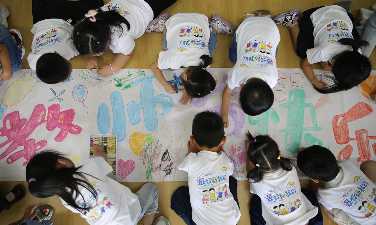 Students from a kindergarten in Linyi, North China's Shandong Province, create a long scroll with the theme of 