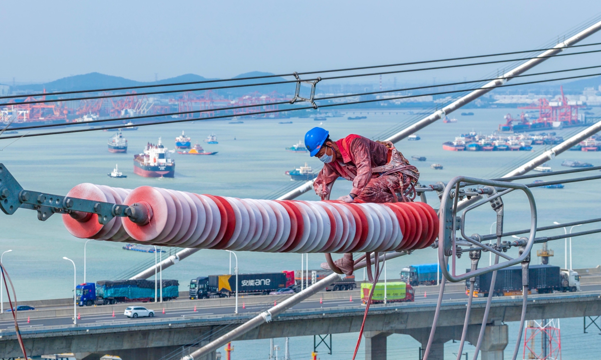 A worker conducts annual maintenance on top of a power line of the Yangzhou-Zhenjiang ±200 kilovolt direct-current transmission project, China's first alternating-current to direct-current power conversion project, in Zhenjiang, East China's Jiangsu Province on September 10, 2025. China's total electricity consumption in July made history by surpassing the 1 trillion kilowatt-hour threshold, according to official data. Photo: cnsphoto