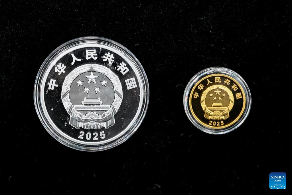 This photo taken on Sept. 19, 2025 shows a set of commemorative coins to mark the 70th anniversary of the establishment of Xinjiang Uygur Autonomous Region. The People's Bank of China on Friday issued a set of gold and silver commemorative coins to mark the 70th anniversary of the establishment of Xinjiang Uygur Autonomous Region in northwest China. The set, which consists of one gold coin and one silver coin, is legal tender in China. (Xinhua/Ding Lei)