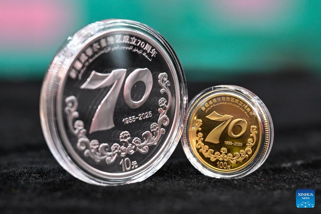 This photo taken on Sept. 19, 2025 shows a set of commemorative coins to mark the 70th anniversary of the establishment of Xinjiang Uygur Autonomous Region.The People's Bank of China on Friday issued a set of gold and silver commemorative coins to mark the 70th anniversary of the establishment of Xinjiang Uygur Autonomous Region in northwest China.The set, which consists of one gold coin and one silver coin, is legal tender in China. (Xinhua/Ding Lei)