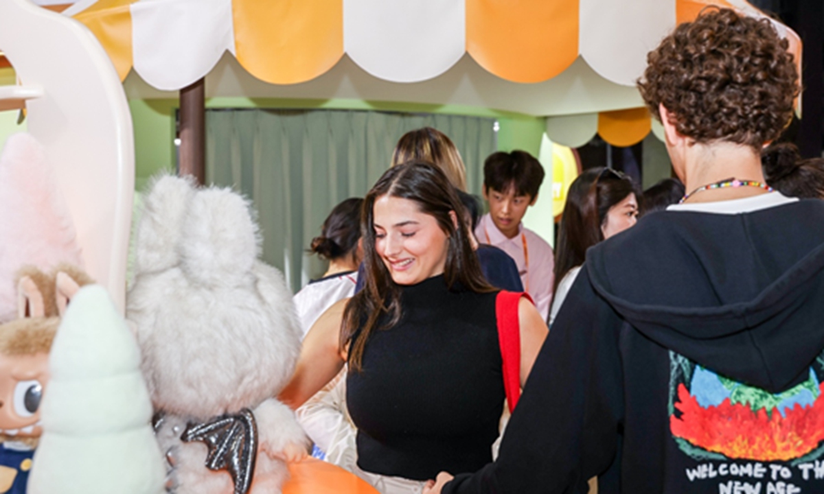 Foreign visitors discuss exhibits at Pop Mart's pavilion during CIFTIS on September 12, 2025. Photo: Courtesy of CIFTIS