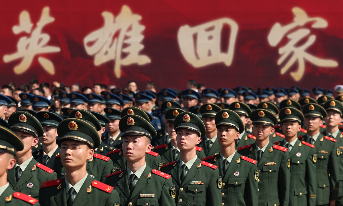 Soldiers attend an arrival ceremony for the remains of Chinese People's Volunteers (CPV) martyrs at Taoxian International Airport in Shenyang, Northeast China's Liaoning Province, September 12, 2025. The billboard behind the soldiers reads The heroes return. Photo: Cui Meng/GT