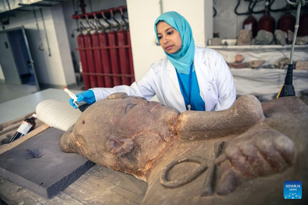 A conservator works on an ancient colossal statue at a conservation lab of the National Museum of Egyptian Civilization (NMEC) in Cairo, Egypt, on Sept. 2, 2025. While visitors wander the sunlit halls above, marveling at treasures carved millennia ago, a quieter, more meticulous drama unfolds beneath their feet, in the shadowed depths of the NMEC. (Photo: Xinhua)