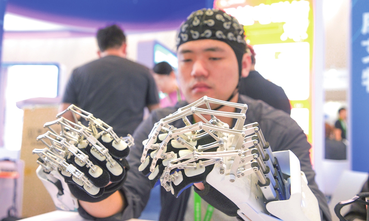 A visitor tries out simulated exoskeleton finger rehabilitation trainers at the 2025 Care & Rehabilitation Expo China held in Beijing on September 14, 2025. The expo, attracting more than 400 domestic and international enterprises and institutions, showcases more than 10,000 innovative assistive technology products and serves as a platform for displaying rehabilitation achievements and fostering cooperation. Photo: VCG