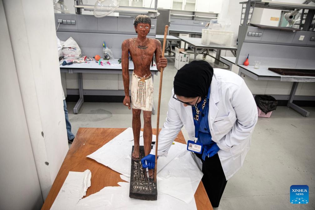 A conservator works on an ancient statue at a conservation lab of the National Museum of Egyptian Civilization (NMEC) in Cairo, Egypt, on Sept. 2, 2025. While visitors wander the sunlit halls above, marveling at treasures carved millennia ago, a quieter, more meticulous drama unfolds beneath their feet, in the shadowed depths of the NMEC. (Photo: Xinhua)