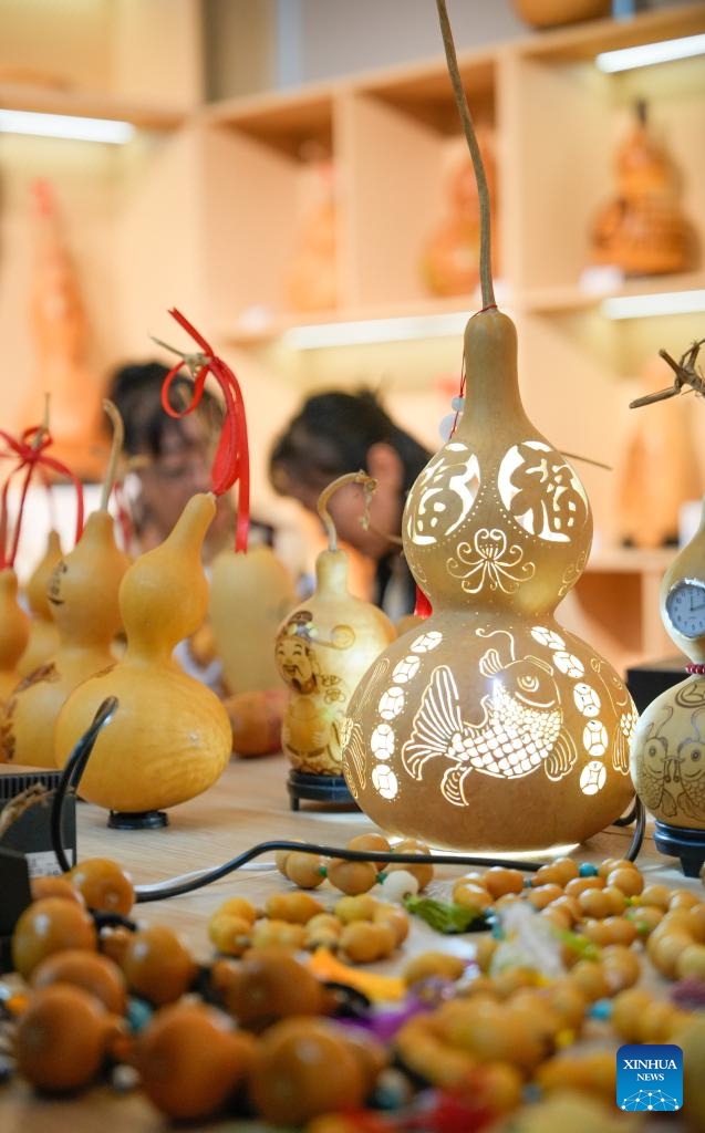 Traditional culture enthusiasts make gourd pyrography works at the Emin County memory museum in Emin County, northwest China's Xinjiang Uygur Autonomous Region, Sept. 13, 2025. While showcasing multi-ethnic culture and local history of the county, the museum has attracted many artisans and traditional culture lovers for handicraft exchange. (Photo: Xinhua)